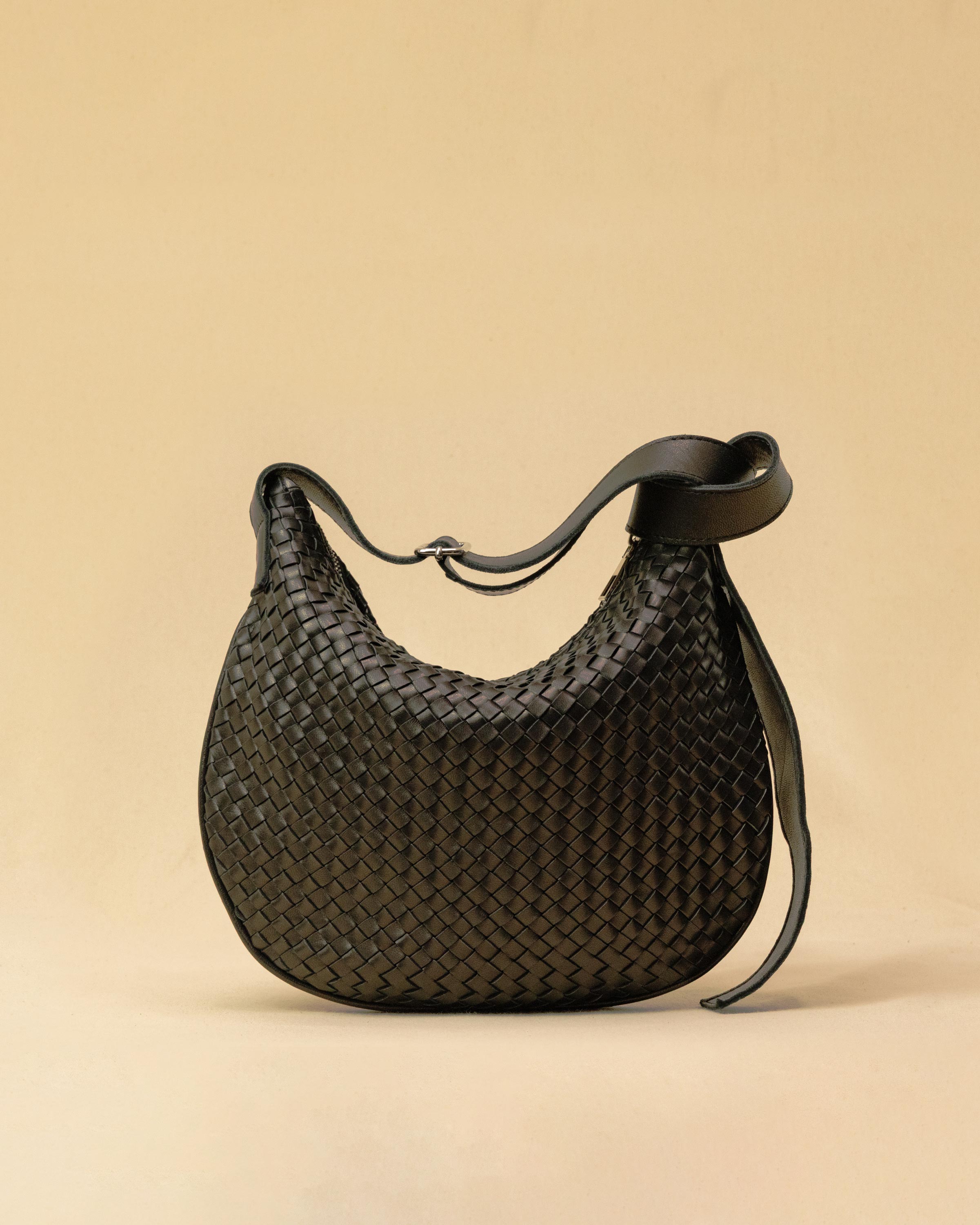 Die SHOULDER BAG SADDLE LUNA Medium in Black von LABEL17 ist aus feinstem, pflanzlich gegerbtem Nappaleder von Hand geflochten. Die Tasche hat einen Reissverschluss und einen ledergefütterten Innenraum mit Seitenfach. Dank dem verstellbaren Schulterriemen ist sie als Schultertasche oder Crossbody zu tragen.