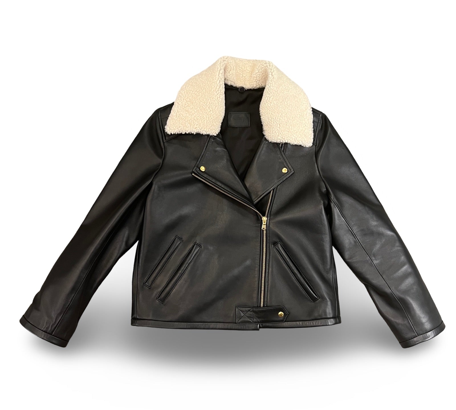 Die schwarze Lederjacke KATE von LABEL17, eine klassische Perfecto, überzeugt durch stilvolle Details wie den abnehmbaren Lammfell-Kragen-Besatz. Gefertigt aus feinstem Nappaleder, ist diese Jacke ein zeitloses Highlight. Die goldenen Beschläge verleihen dem Design einen lässigen, und gleichzeitig eleganten Touch. Diese Jacke von höchster Qualität ist eine gute Investition und wird Sie jahrelang begleiten.