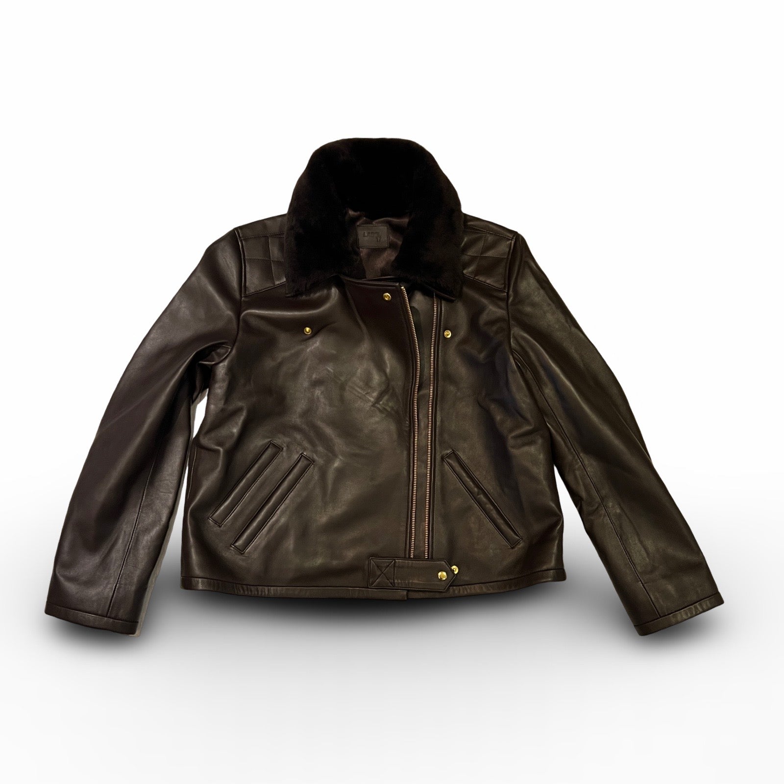 Die dunkelbraune Lederjacke KATE von LABEL17, eine klassische Perfecto, überzeugt durch stilvolle Details wie den abnehmbaren Lammfell-Kragen-Besatz. Gefertigt aus feinstem Nappaleder, ist diese Jacke ein zeitloses Highlight. Die goldenen Beschläge verleihen dem Design einen lässigen, und gleichzeitig eleganten Touch. Diese Jacke von höchster Qualität ist eine gute Investition und wird Sie jahrelang begleiten.