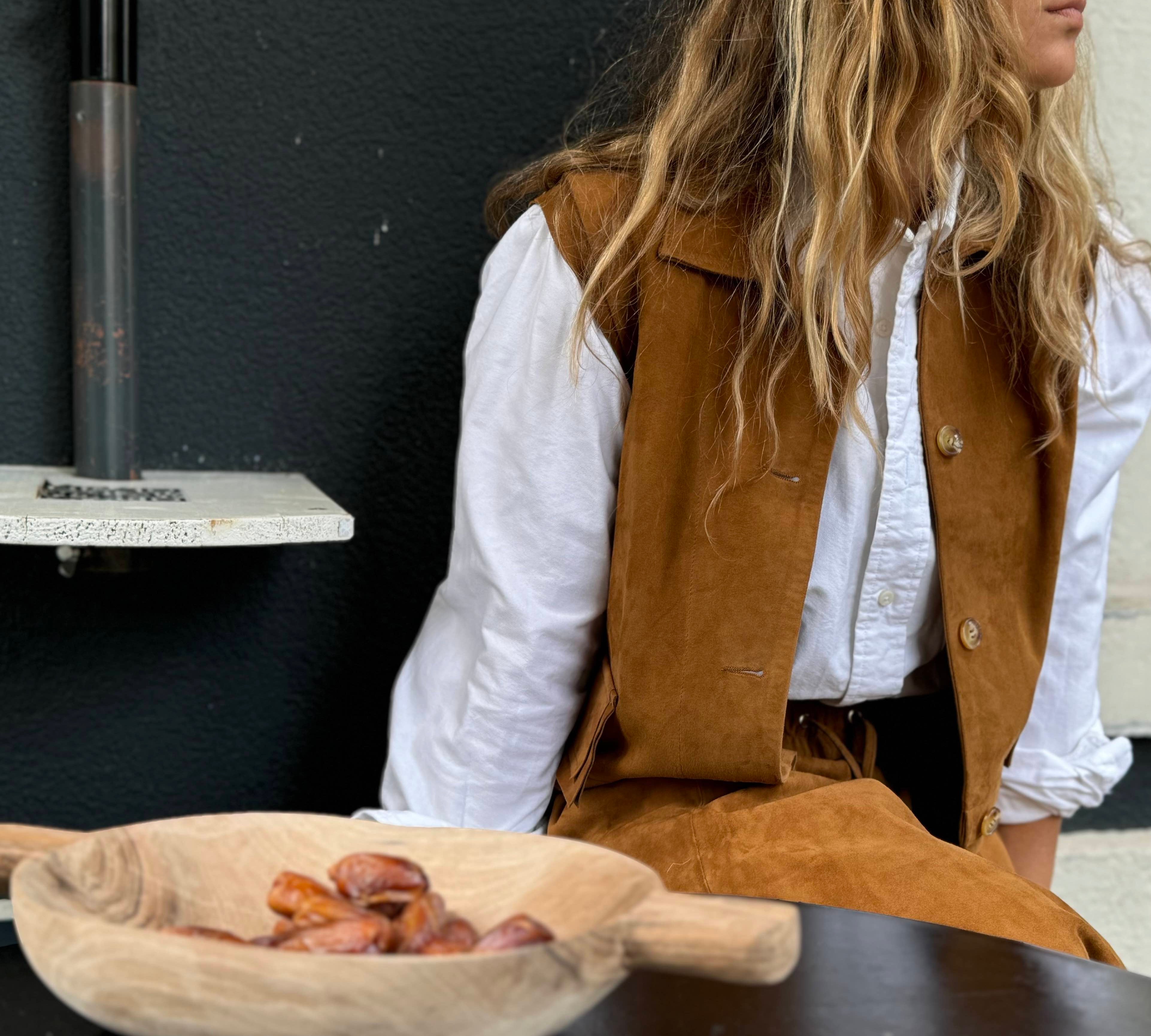 LDie Leder Veste BABAH von LABEL17 ist aus weichem Velours-Nappaleder gefertigt und bietet einen luxuriösen Tragekomfort. Dieses vielseitige Stück lässt sich als stilvolles Accessoire über einem klassischen weißen Hemd tragen und mit deiner Lieblingsjeans kombinieren, oder in Verbindung mit unserem Lederrock JACKIE für ein mutiges, elegantes Outfit. 