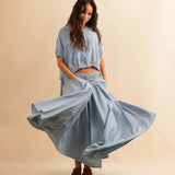 Der Skirt CRISTY von LABEL17 in einem klassischen Blau-Weiss Vichy-Karo-Muster fällt in einer weiten Maxi-Länge und verleiht jedem Look eine feminine Leichtigkeit. Zwei Zierschnallen im Bund setzen einen eleganten Akzent. Reissverschluss vorne und elastischer Bund hinten sorgen für angenehmen Tragekomfort.