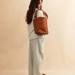 Shoulder Bag ABBIE in Cognac von LABEL17, aus geschmeidigem Lamm-Nappaleder von Hand geflochten. Beutelform mit kurzem und langem Schulterhenkel, hergestellt in Marokko.