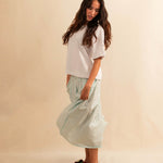 LABEL17's Skirt LINA ist ein Faltenrock aus Baumwolle, veredelt mit einem handgenähten Zierstich (Hbik-Stitch) an der linken und rechten Seite. Falten auf der Vorderseite und ein elastischer Einsatz am Rücken sorgen für angenehmen Tragekomfort. Perfekt für den Sommer.