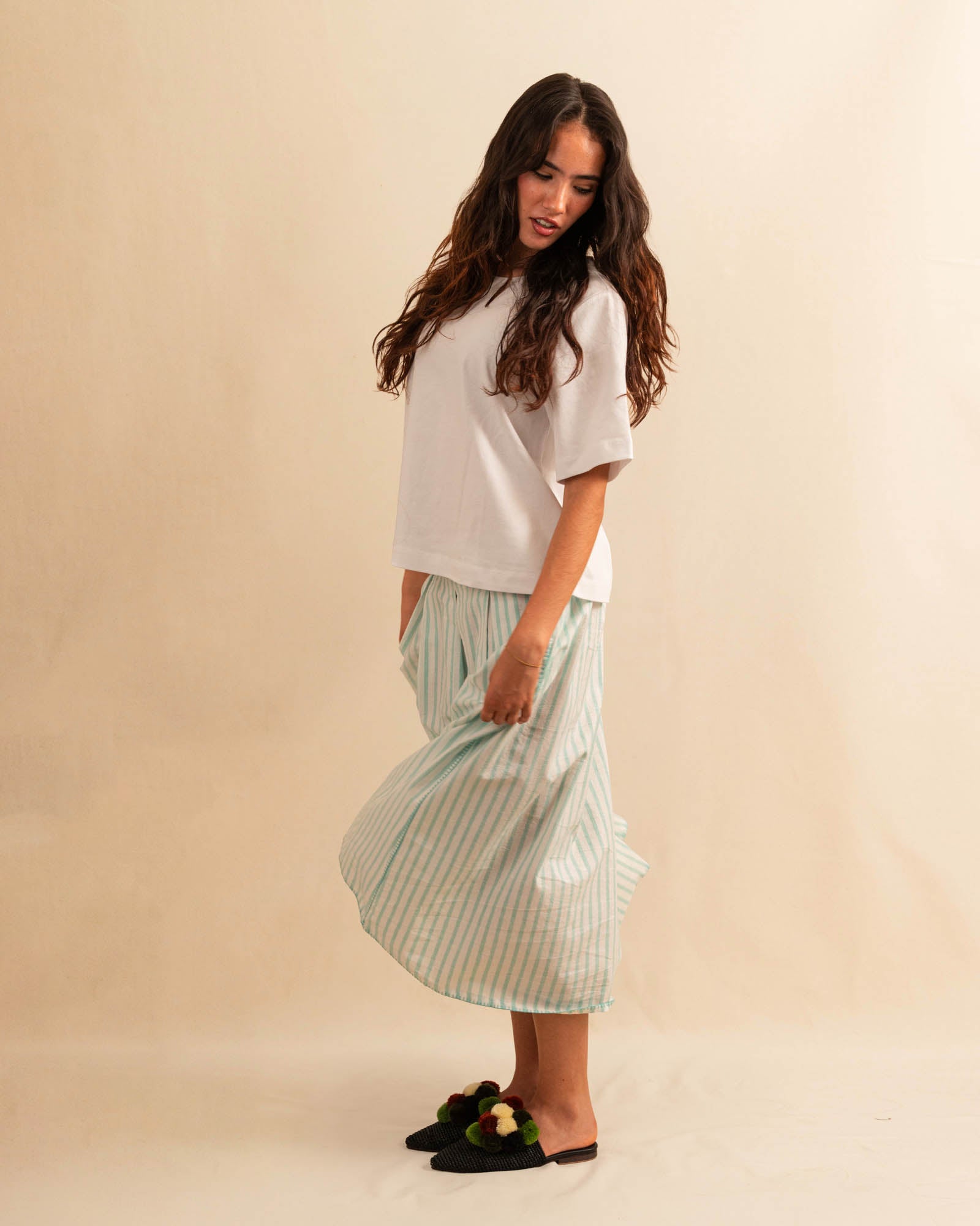 LABEL17's Skirt LINA ist ein Faltenrock aus Baumwolle, veredelt mit einem handgenähten Zierstich (Hbik-Stitch) an der linken und rechten Seite. Falten auf der Vorderseite und ein elastischer Einsatz am Rücken sorgen für angenehmen Tragekomfort. Perfekt für den Sommer.