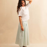 LABEL17's Skirt LINA ist ein Faltenrock aus Baumwolle, veredelt mit einem handgenähten Zierstich (Hbik-Stitch) an der linken und rechten Seite. Falten auf der Vorderseite und ein elastischer Einsatz am Rücken sorgen für angenehmen Tragekomfort. Perfekt für den Sommer.