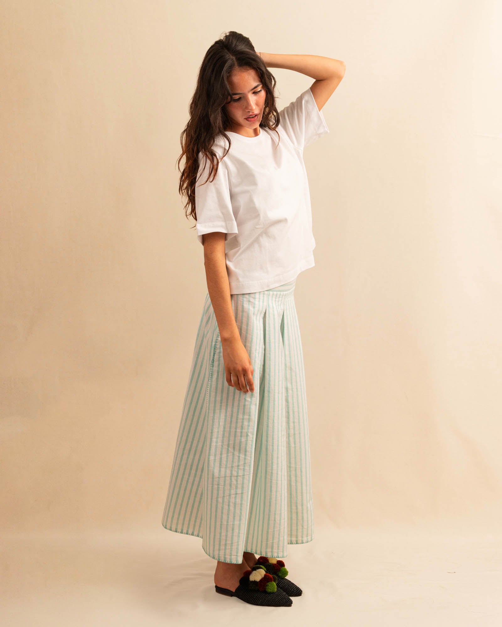 LABEL17's Skirt LINA ist ein Faltenrock aus Baumwolle, veredelt mit einem handgenähten Zierstich (Hbik-Stitch) an der linken und rechten Seite. Falten auf der Vorderseite und ein elastischer Einsatz am Rücken sorgen für angenehmen Tragekomfort. Perfekt für den Sommer.