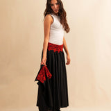 Der Skirt LACE in Night Blue aus hochwertigem Baumwollmischgewebe fällt in einer weiten Maxi-Länge und besticht durch die rote Spitzenapplikation am Bund – ein kühnes Detail, das dem schlichten Rock eine dramatische Note verleiht. Reissverschluss für eine saubere Silhouette.