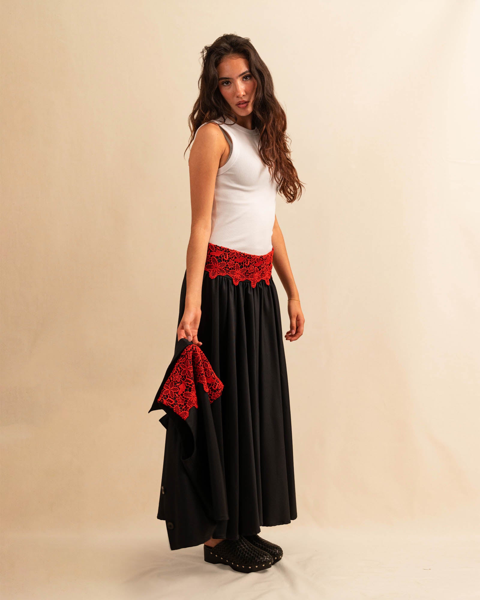 Der Skirt LACE in Night Blue aus hochwertigem Baumwollmischgewebe fällt in einer weiten Maxi-Länge und besticht durch die rote Spitzenapplikation am Bund – ein kühnes Detail, das dem schlichten Rock eine dramatische Note verleiht. Reissverschluss für eine saubere Silhouette.