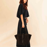 Die Shoulder Bag IVY von LABEL17 ist aus geschmeidigem Velours-Leder gefertigt und zeichnet sich durch handwerkliche Details wie markante Seitennähte und lange, geflochtene Henkel aus. Mit den Lederbändern lässt sich die Tasche elegant zuschnüren – eine gelungene Verbindung von Funktion und Raffinesse.