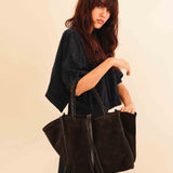 Die Shoulder Bag IVY von LABEL17 ist aus geschmeidigem Velours-Leder gefertigt und zeichnet sich durch handwerkliche Details wie markante Seitennähte und lange, geflochtene Henkel aus. Mit den Lederbändern lässt sich die Tasche elegant zuschnüren – eine gelungene Verbindung von Funktion und Raffinesse.