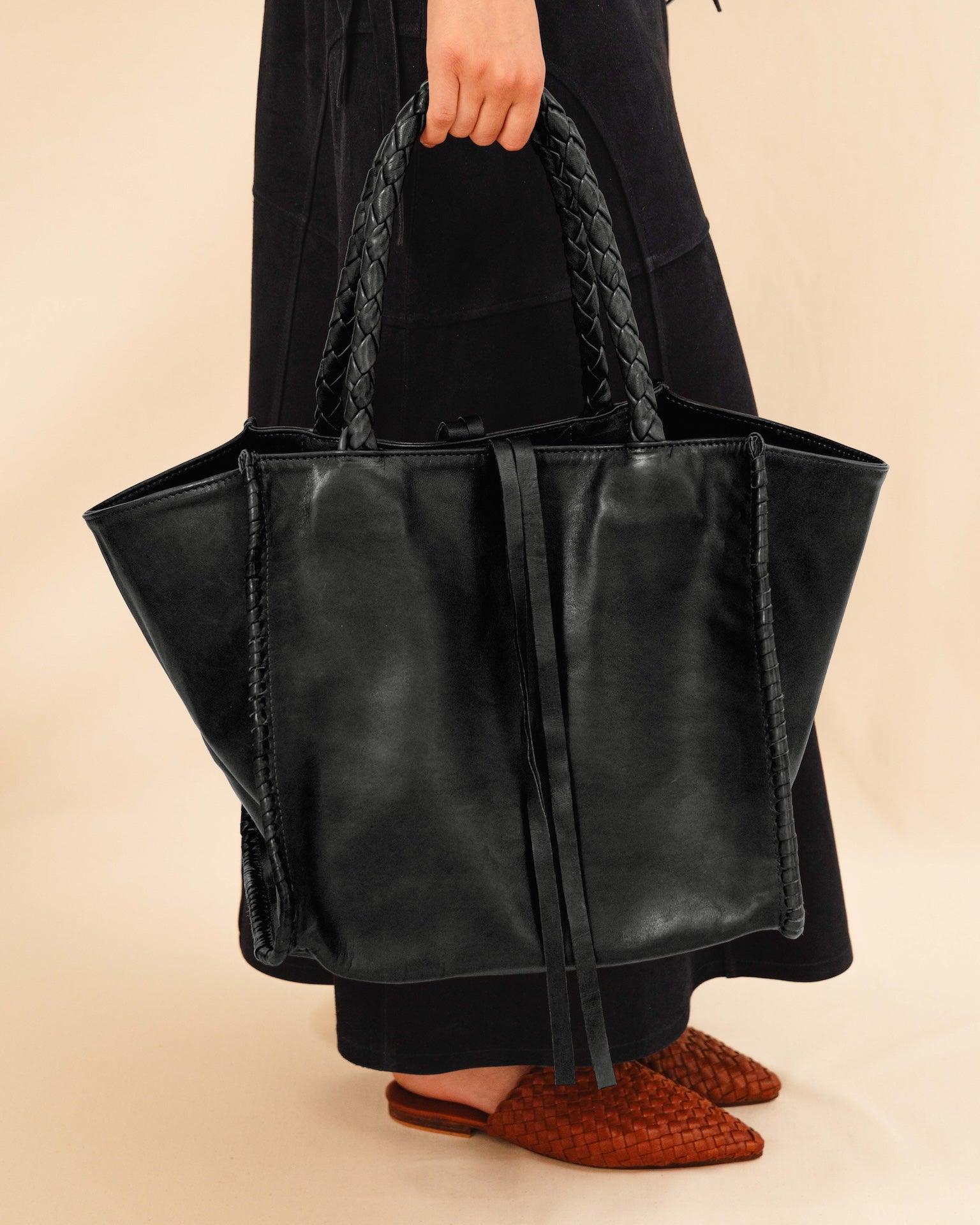 Die Shoulder Bag IVY von LABEL17 ist aus geschmeidigem Nappaleder gefertigt und zeichnet sich durch handwerkliche Details wie markante Seitennähte und lange, geflochtene Henkel aus. Mit den Lederbändern lässt sich die Tasche elegant zuschnüren – eine gelungene Verbindung von Funktion und Raffinesse.