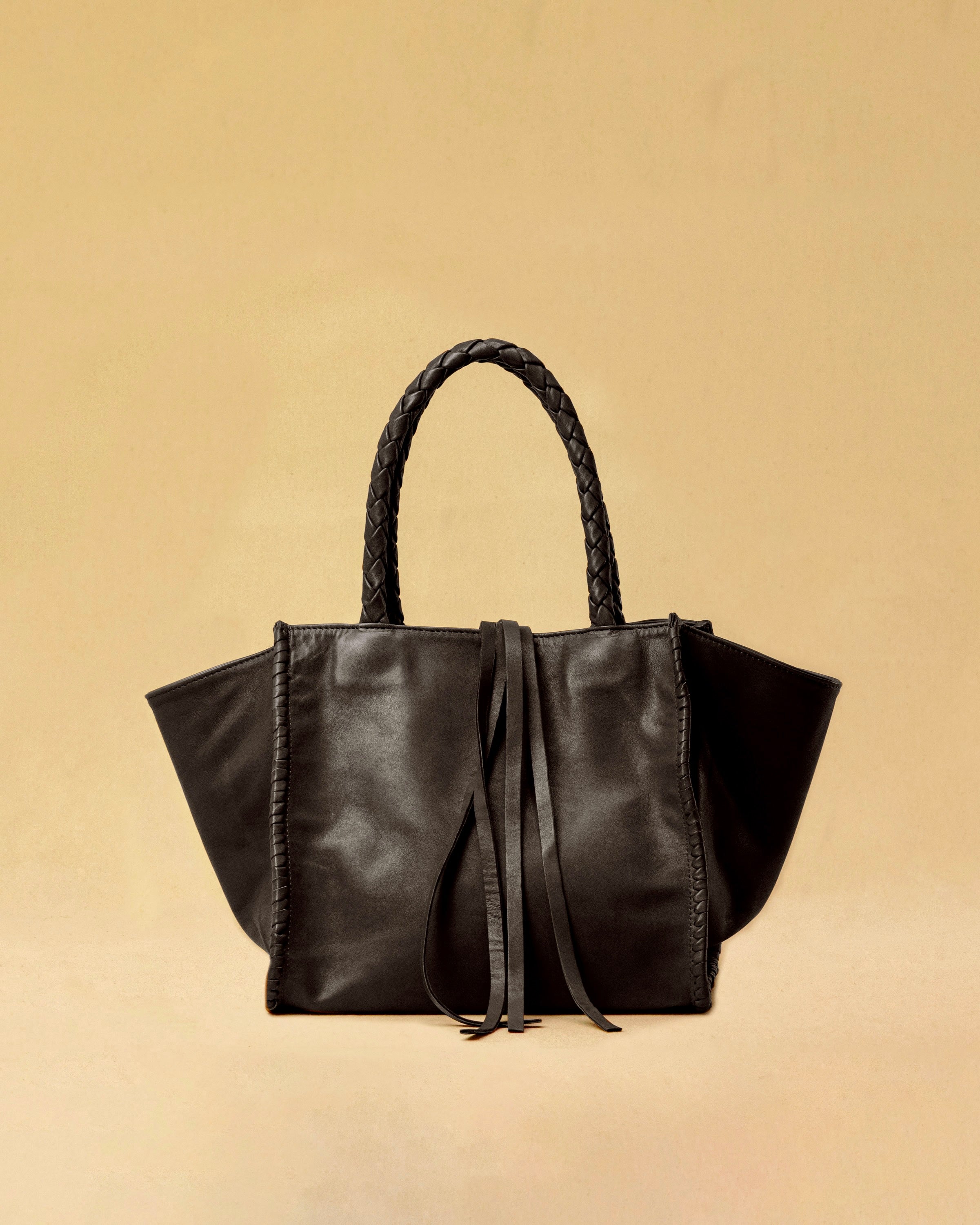 Die Shoulder Bag IVY ist aus geschmeidigem Nappaleder gefertigt und zeichnet sich durch handwerkliche Details wie markante Seitennähte und lange, geflochtene Henkel aus. Mit den Lederbändern lässt sich die Tasche elegant zuschnüren – eine gelungene Verbindung von Funktion und Raffinesse.&nbsp;